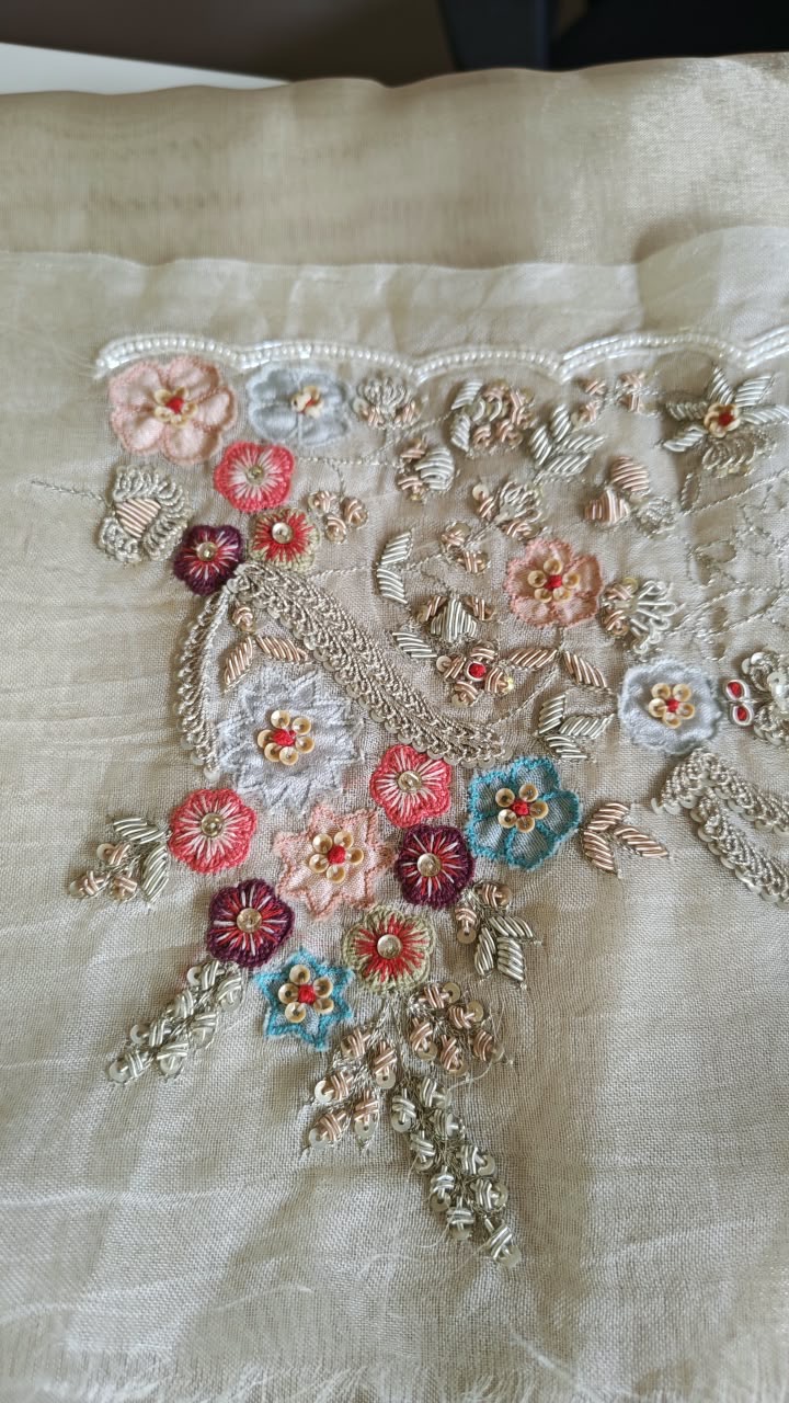 A shaped neckline border with small pink, blue and green floral details.