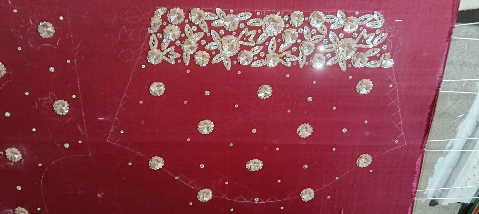A wider view of a red panel with small motifs and a decorative edge.