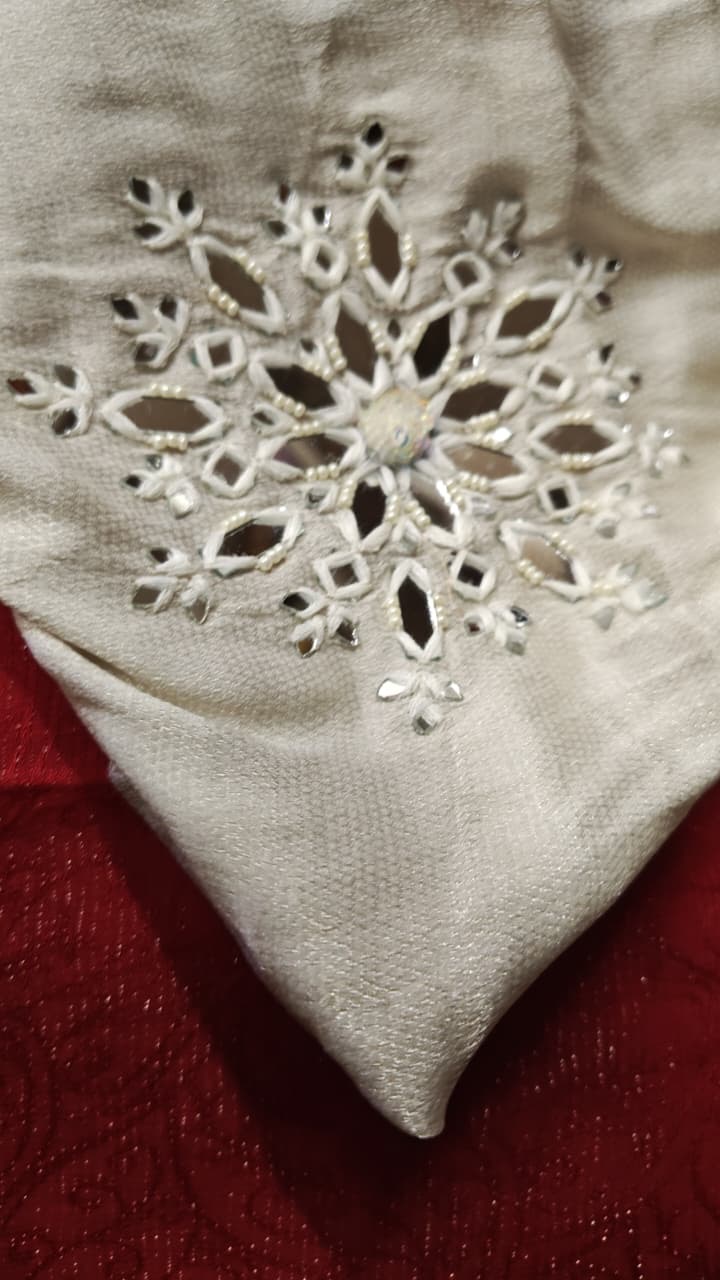 A close view of open flower shapes worked into pale fabric.