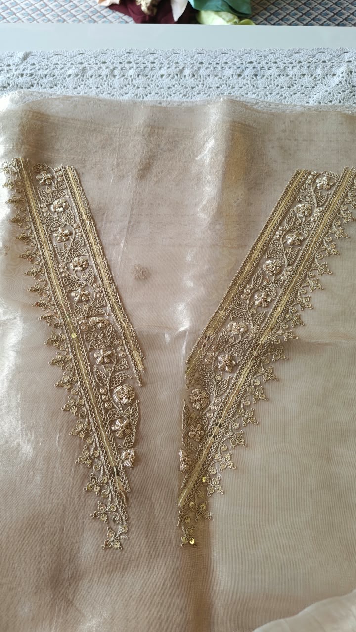 A deep V outlined with narrow lines of gold-toned embroidery.