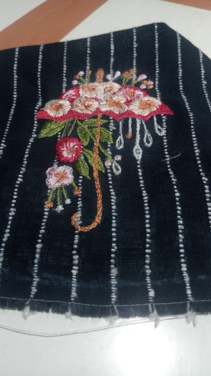 A colourful floral umbrella motif against a dark striped ground.