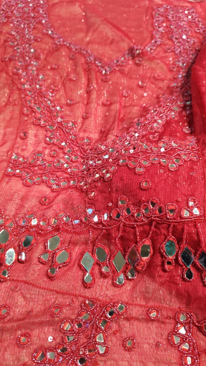 A coral fabric detail with openwork, loops and reflective accents.