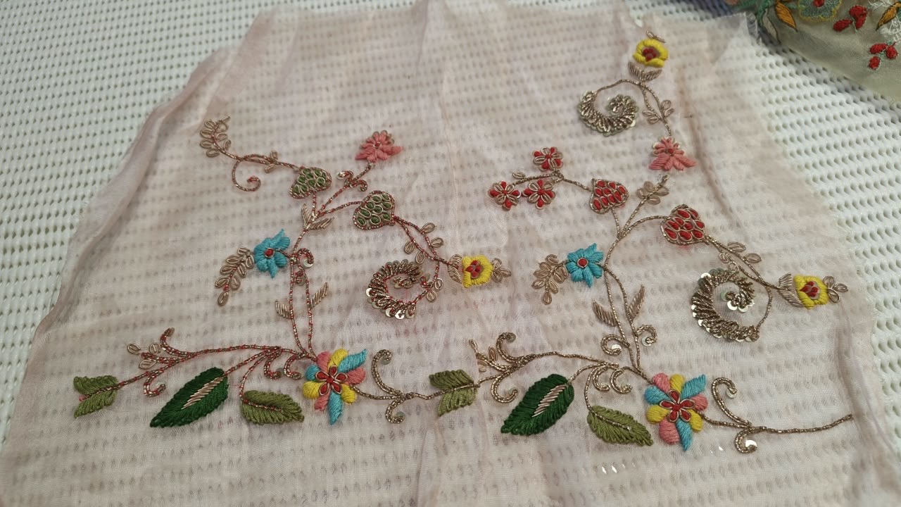 Fine branches and small multicoloured flowers across pale fabric.