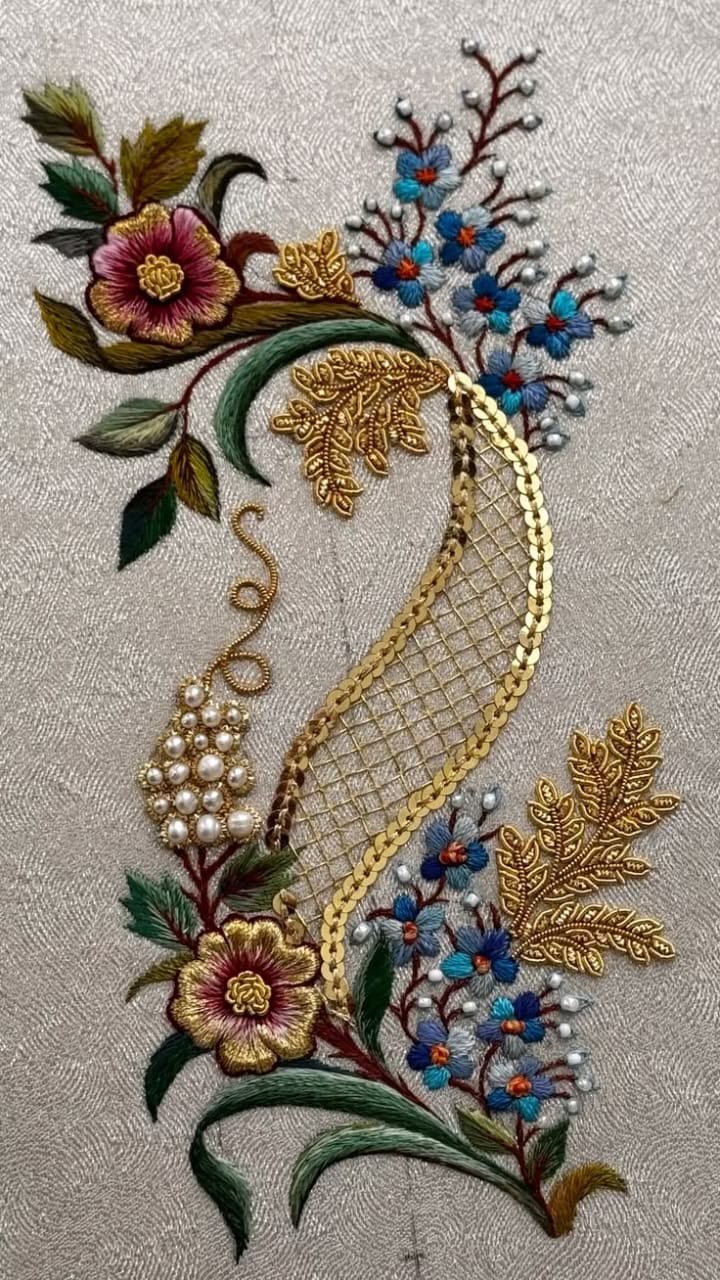 An embroidery reference with a peacock, trailing flowers and pearl-like details.